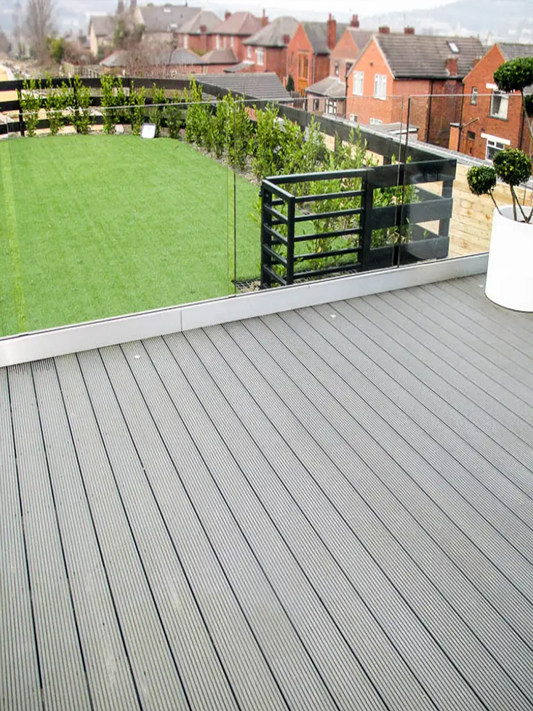 Three construction workers applying bright light blue waterproof coating on outdoor planter